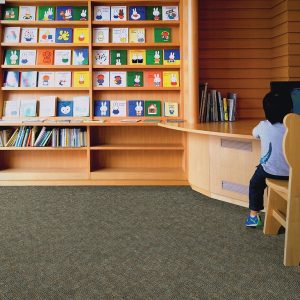 Boy Sitting At Library Reception Desk